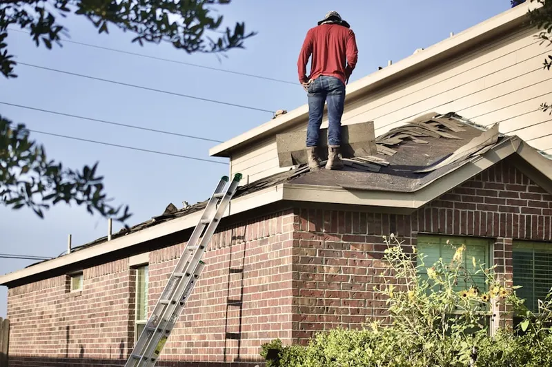 Professional roofer working on a residential roof in Bloomfield Hills